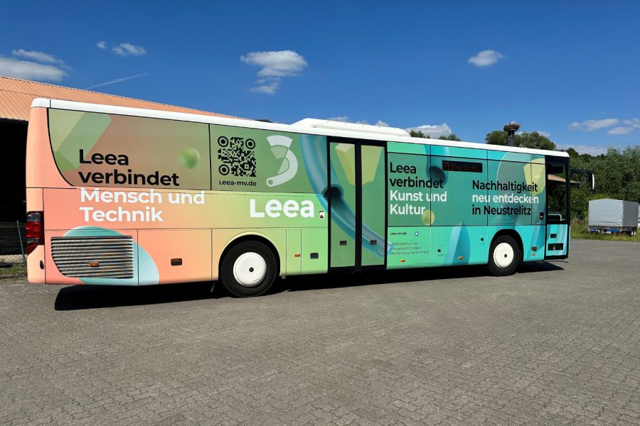 Ein Linienbus steht auf einem Hof und ist mit einer farbenfrohen Werbung für das Landeszentrum für erneuerbare Energien Mecklenburg-Vorpommern beklebt