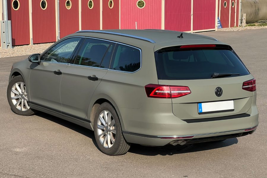 Ein khaki-grün folierter VW Passat ist von hinten zu sehen.